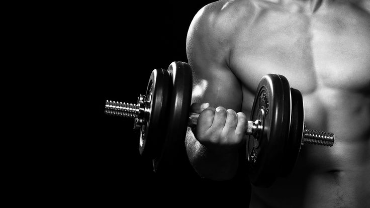 Man lifting dumbbell in gym.